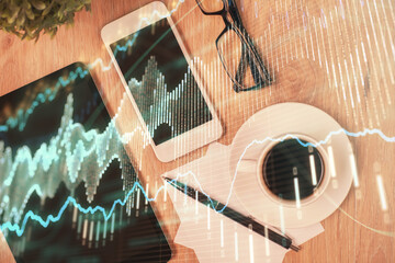 Double exposure of forex chart hologram over desktop with phone. Top view. Mobile trade platform concept.