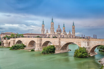 Fototapeta na wymiar Zaragoza, Spain. View of historic Puente de Piedra bridge. Long exposure shot with HDR effect