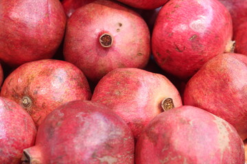 Fresh raw organic garnet fruit pile texture background. Red pomegranate fruits