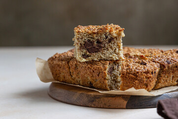 Oatmeal squares with chocolate, light concrete background. Diet bars. Healthy bakery for breakfast or dessert.