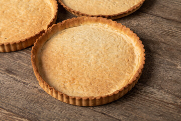 baked, empty tart shells on wooden table 