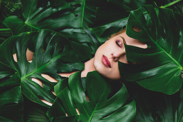 Beautiful white woman with palm leaves around