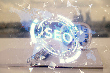 Multi exposure of SEO drawings and desk with open notebook background. Concept of Search optimization