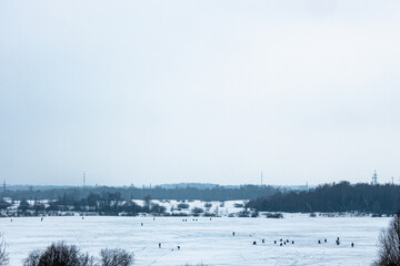 Naklejka premium Winter fishing on a frozen lake, many people fishing on the ice
