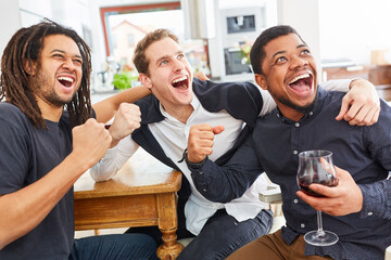 Men as friends cheer together while watching football or sports