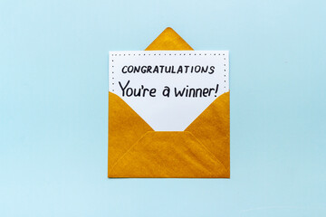 You are a winner. Golden envelope with congratulation card. Top view