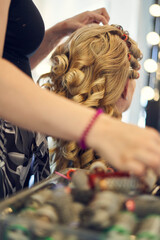 Blonde lockige Braut beim Friseur, getting ready