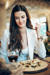 Woman eating pizza in luxury restaurant