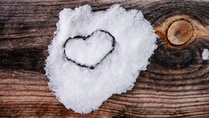 Valentine's Day background. Brown old winter wooden natural boards in with white heart made of snow. Top view. Surface of table to shoot flat lay. Concept love, romantic relation.
