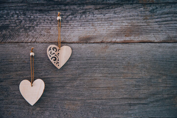 Valentine's Day background. Brown natural boards in grunge style with two wooden decorative hearts. Top view. Surface of table to shoot flat lay. Concept love, romantic relation. Copy space for text.