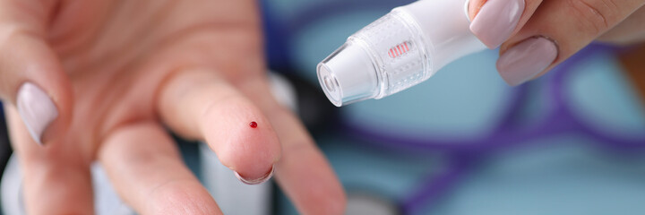 Blood sampling from a finger with lancet. Blood test concept