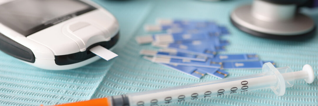 There is syringe and stethoscope on the table. Determination of blood sugar in diabetes concept