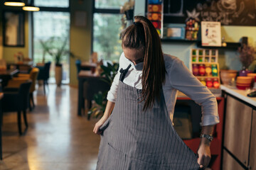 waitress preparing for work in restaurant or cafe