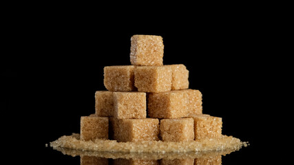 brown sugar cubes on black background. Demerara golden brown sugar