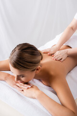 Obraz na płótnie Canvas masseur massaging back of client lying on massage table