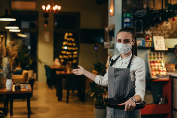waitress welcomes guests in restaurant or cafe