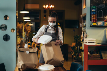 waitress preparing food for delivery in restaurant
