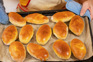 On the baking sheet are ready-made Russian pies with filling. Homemade baking