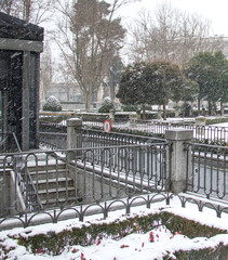 the access to a car parking area down street by stone staircase the city in a cold winter snowfall day