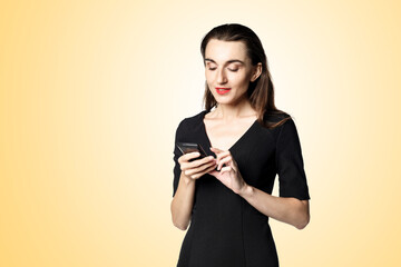 Business woman (fatal woman) in a black dress with red lipstick looks at her phone, isolated on a...