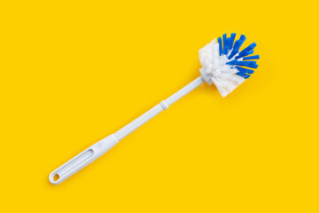 Toilet brush on yellow background.