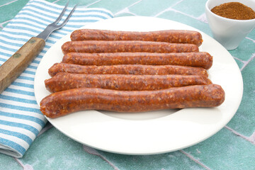 assiette de merguez crues sur une table