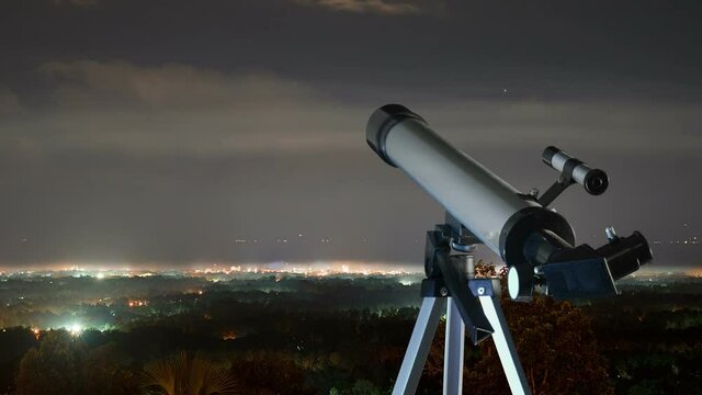 Night skyline, cityscape, telescope in foreground with downtown in the background. Timelapse.