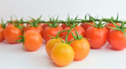 Close up. Small fresh and beneficial branch tomatoes. White background.