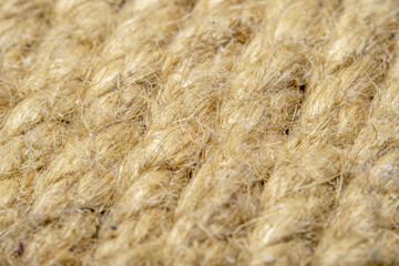A background of roughly knitted fabric in soft focus under high magnification. Synthetic fabric stylized as an old, chunky-knit linen thread.