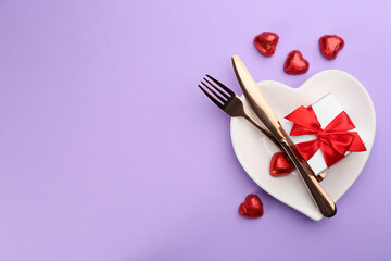Beautiful table setting on violet background, flat lay with space for text. Valentine's Day dinner