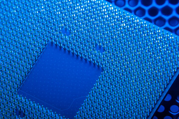 Close-up of a part of a microprocessor in soft focus under high magnification. Details of a computer component under a microscope in tech blue light.