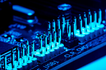 High tech dark background with elements of a computer motherboard in soft focus under high magnification. A close-up of the internal usb connectors on a home computer board.