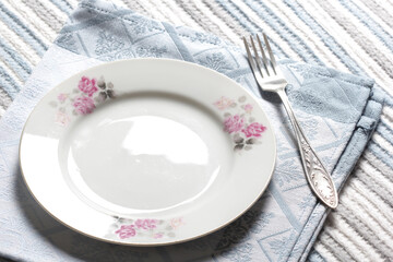 empty plate, fork and napkin on the table