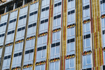 Residential high-rise building under construction. Unfinished house on a construction site with cranes.