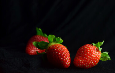 Fresh strawberries, black background and copy space.