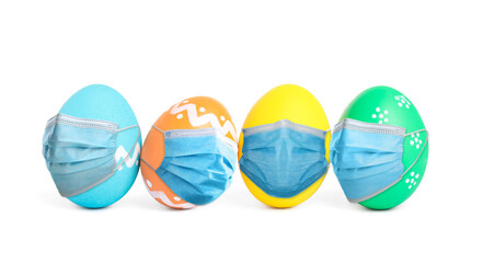 COVID-19 pandemic. Colorful Easter eggs in protective masks on white background