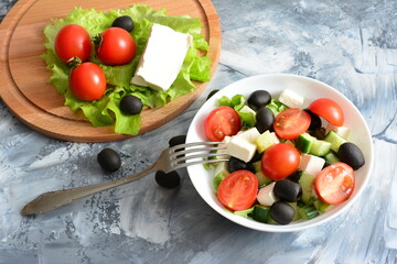 greek salad with tomatoes feta cucumber and olives on the concrete background