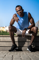 Man of color lies down points to camera sitting