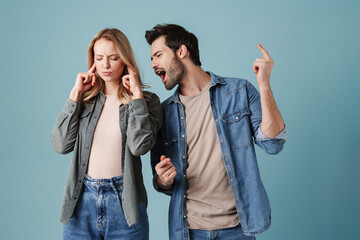 Excited man singing and dancing while his girlfriend plugging her ears