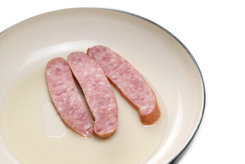 Fried sausages in frying pan isolated on white background