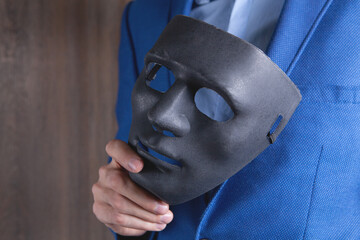 Businessman holding white mask in his hand