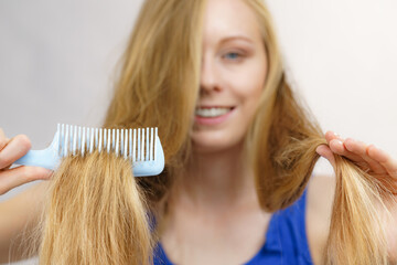 Woman combing long blonde hair