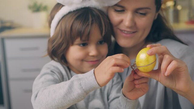 Happy Easter Holiday. Beautiful mother and daughter paint and decorate the egg for the spring traditional dinner at home