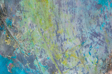colorful creative motley background: smudged residues of oil paints on a wooden palette, short focus, selective blur