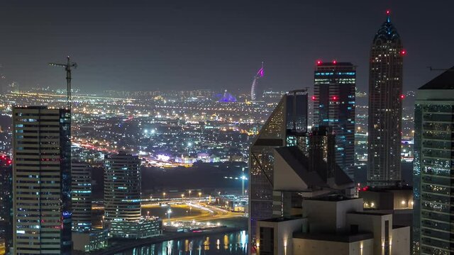 Aerial view of a big modern city at night timelapse with night traffic and illuminated skyscrapers, office buildings. Business bay, Dubai, United Arab Emirates.