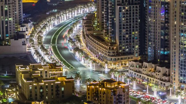 Top view of road intersection in Dubai downtown aerial timelapse with night traffic, metroline and illuminated skyscrapers. This is one of the iconic views of Dubai, UAE