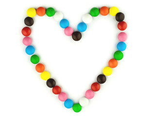 Heart shaped colorful sweets. Bright candy pills on white isolated background. Frame for your photo or text. Mock up