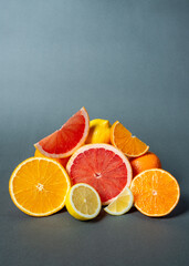 citrus fruits, grapefruits, lemons, oranges, on a grey background.