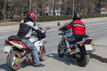 Two men on motorcycles on a city street