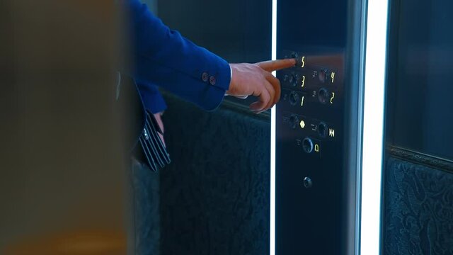 Man pressing elevator button. Traveling businessman with suitcase waiting for elevator in hotel